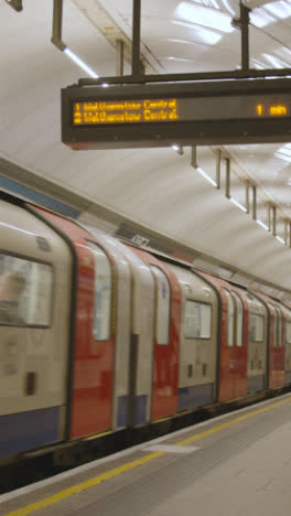 Vertikales-Video-Der-U-Bahn,-Die-Am-Bahnsteig-Der-U-Bahnstation-King&#39;s-Cross-St-Pancras-London-Großbritannien-Ankommt